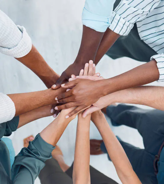 Diverse team joining hands together in community unity